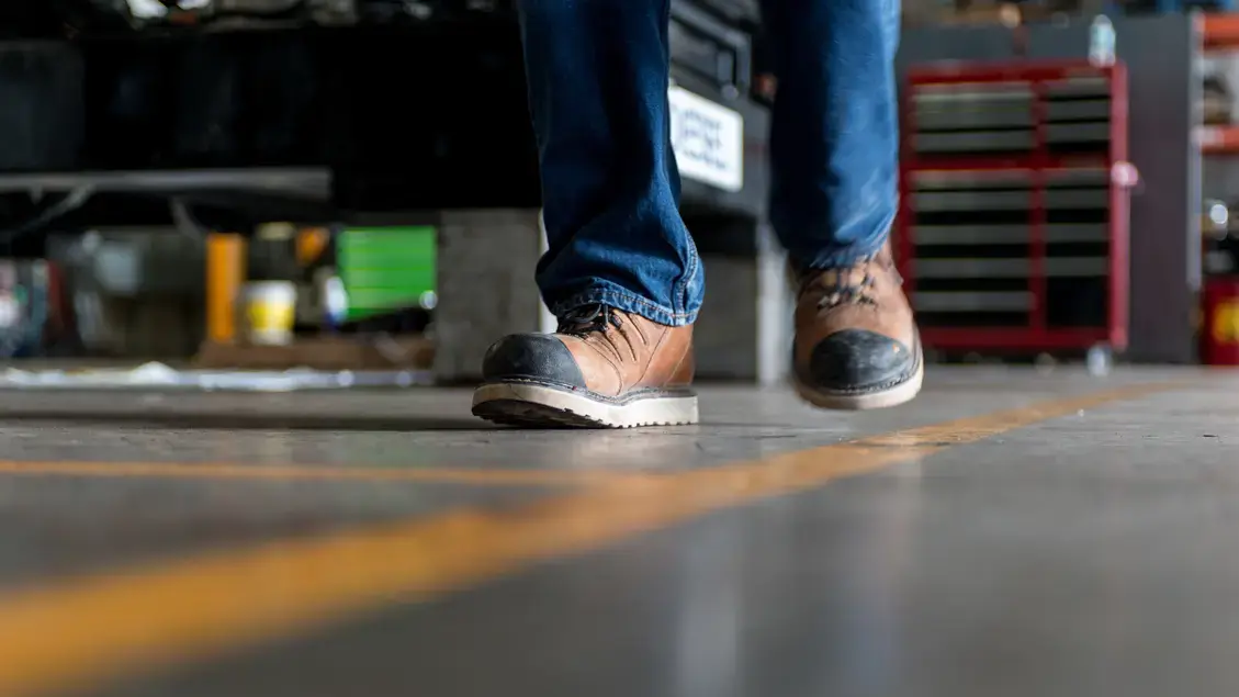 Man in safety boots walking a iine