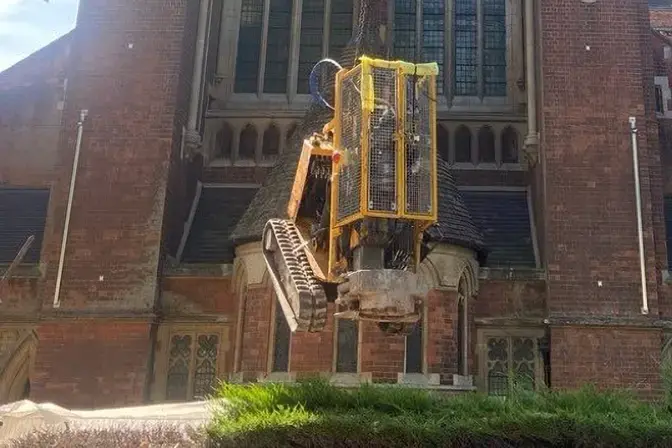 A rig being lowered into the grounds of the Catholic Apostle Church