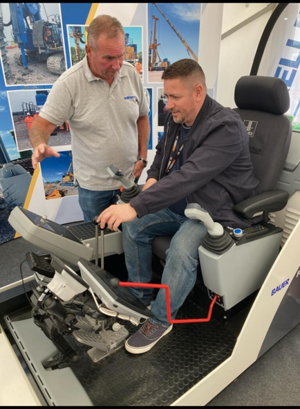 Aaron Armstrong (right) tries out a piling rig simulator