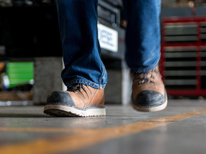 Man in safety boots walking a iine