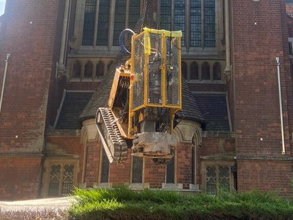 A rig being lowered into the grounds of the Catholic Apostle Church